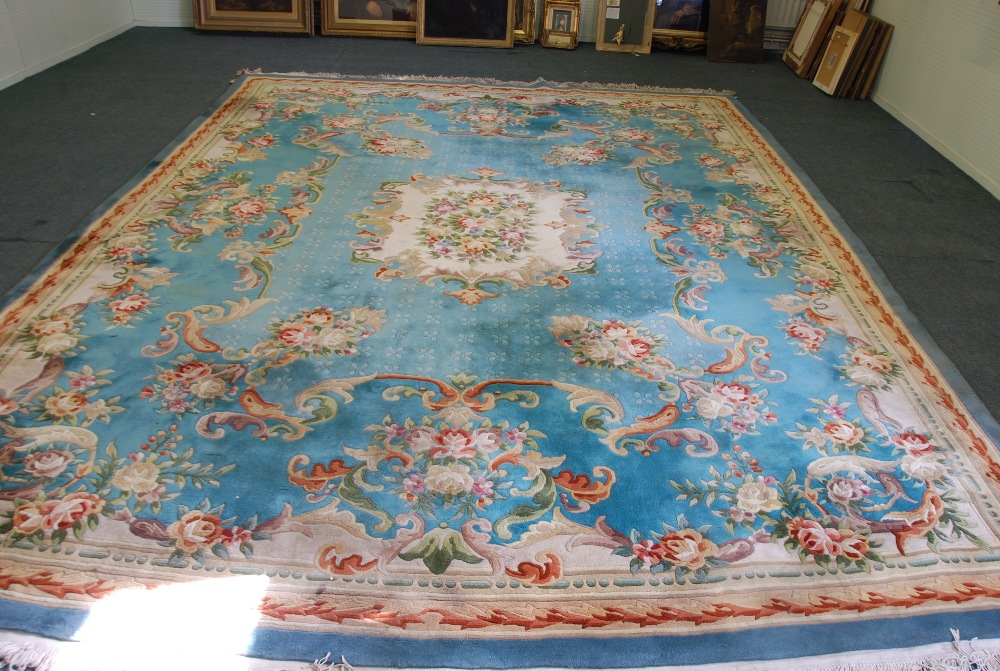 A WASHED CHINESE CARPET OF AUBUSSON DESIGN with off white and floral centre medallion on a pale