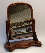 VICTORIAN FIGURED MAHOGANY LARGE TOILET MIRROR, the mirrored plate with arch top and moulded frame,