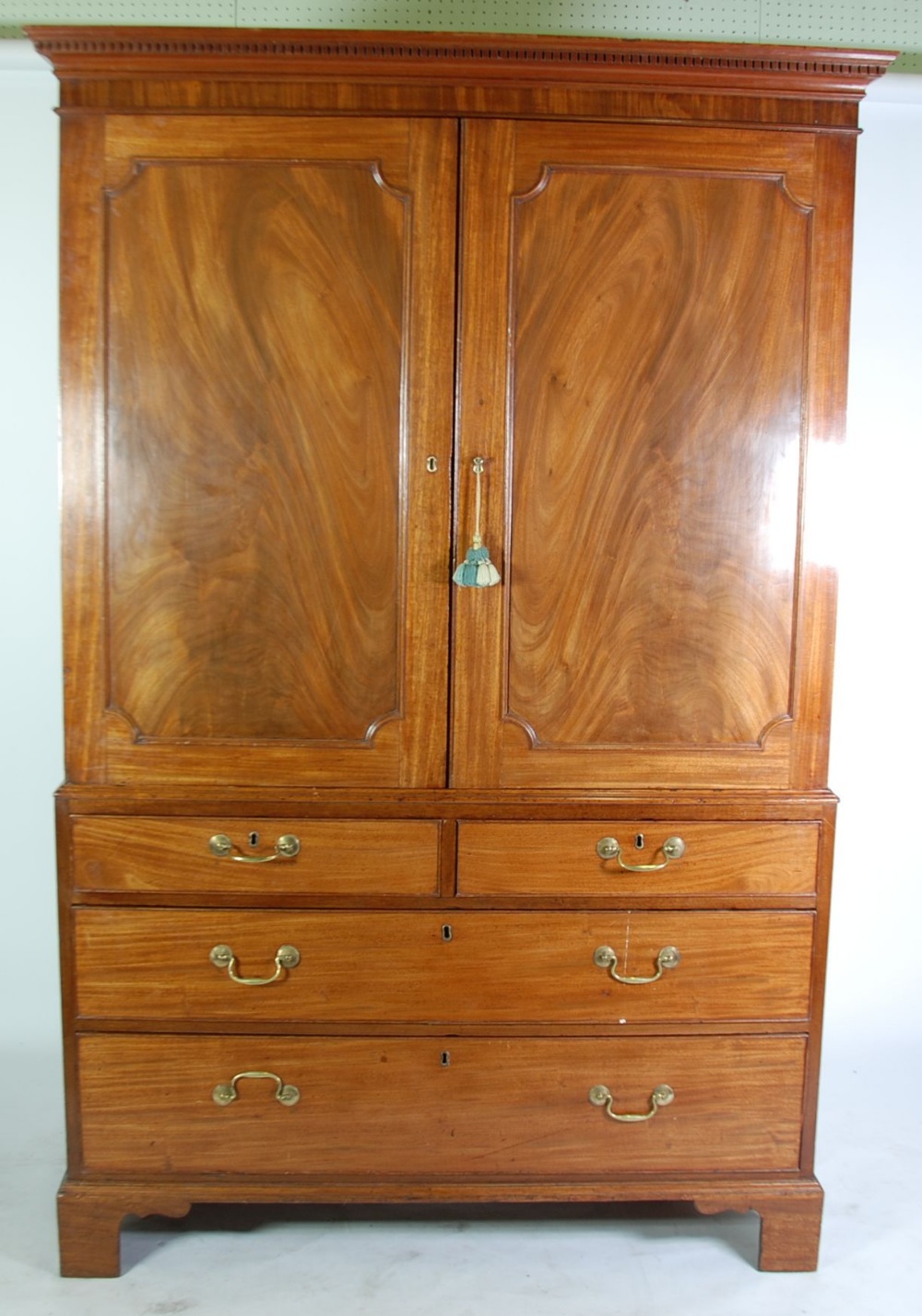 GEORGE III FIGURED MAHOGANY LINEN PRESS, the dentil moulded cornice above a pair of flame cut