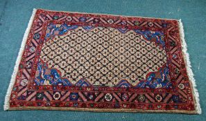 GOREVAN PERSIAN RUG, the centre filled with a fawn close diaper pattern with blue and floral