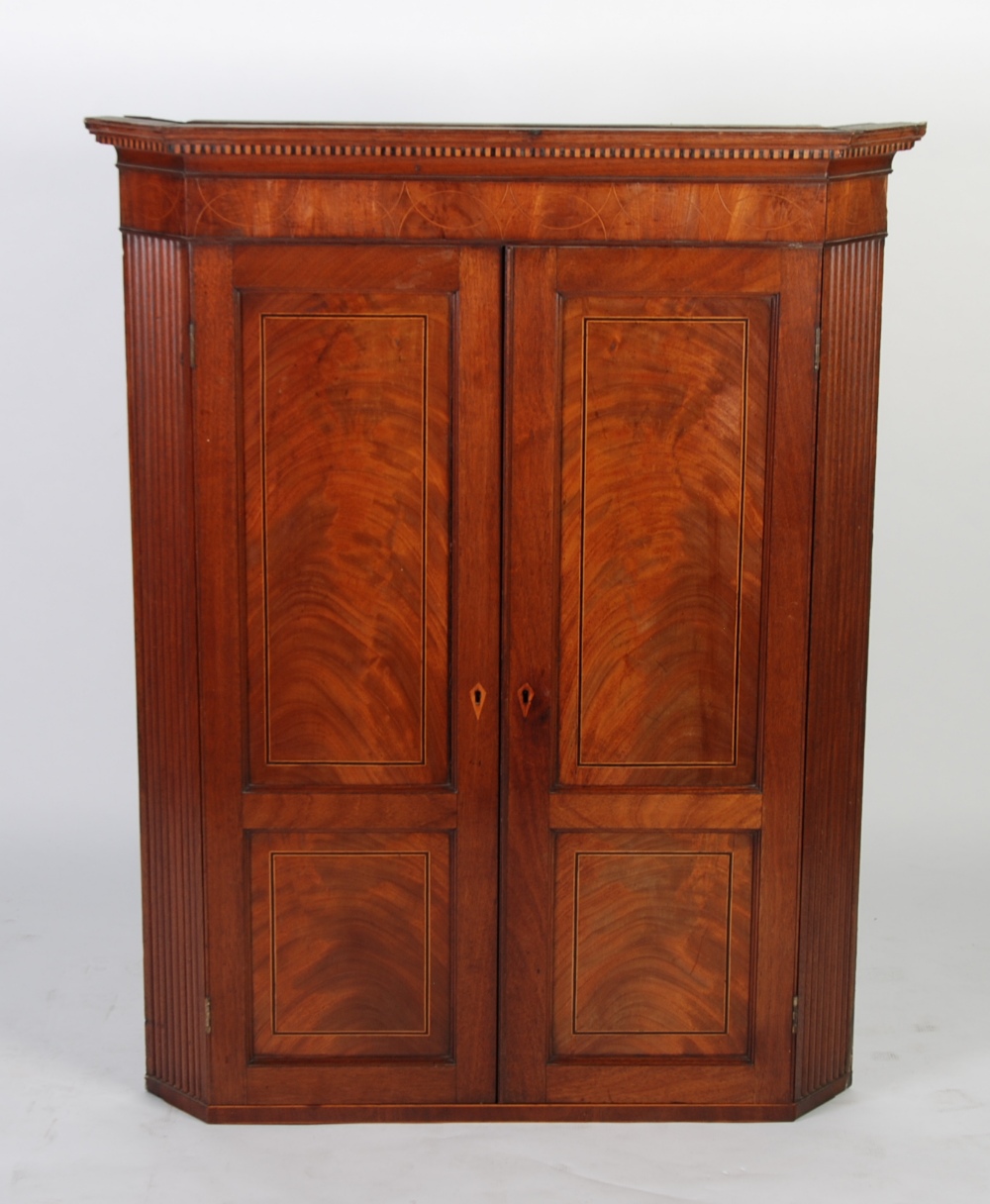 EARLY NINETEENTH CENTURY FLAME CUT MAHOGANY AND LINE INLAID CORNER CUPBOARD, the moulded cornice