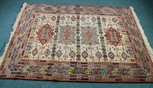 EASTERN RUG, with a row of four large medallions in grey on brick red, on an off white ground with