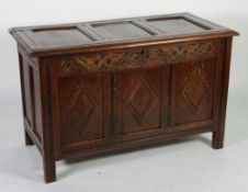 EIGHTEENTH CENTURY CARVED OAK COFFER, the three plank top enclosing a lidded candle box to the