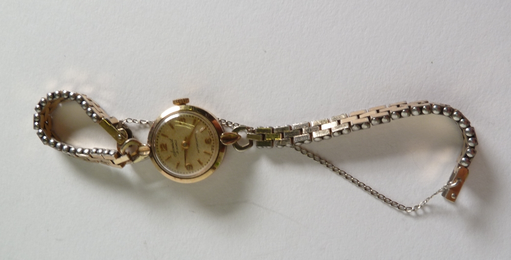 A LADY`S ACCURIST 9CT GOLD WRIST WATCH with 21 jewel movement, a circular gilt arabic dial, gold