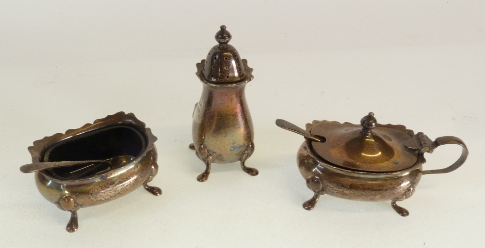A THREE PIECE SILVER CONDIMENT SET, bombe shaped with cyma edge, raised on four pad feet, with