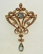 AN EDWARDIAN GOLD, AQUAMARINE AND SEED PEARL OPEN WORK BROOCH, centre set with a circular mixed