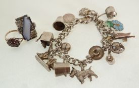A SILVER CHARM BRACELET, WITH FOURTEEN SILVER AND METAL CHARMS, A SILVER AND GOLD GARNET CLUSTER