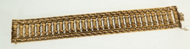 A STAMPED 18CT GOLD BROAD ARTICULATED LINK BRACELET, with textured central band, 1 1/8" (2.8cm)