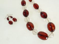 A VINTAGE RED BAKELITE AND CLEAR GLASS BEAD NECKLACE AND A PAIR OF RED BAKELITE EARRINGS