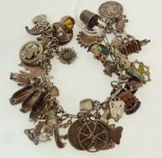 A SILVER CHARM BRACELET, with approx. 43 silver and metal charms