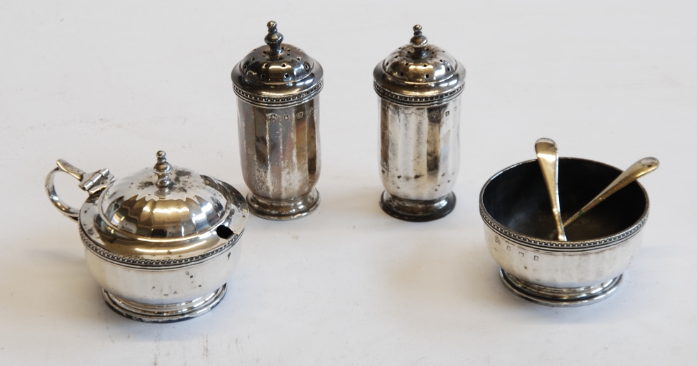 AN EARLY 20TH CENTURY SILVER FOUR PIECE CONDIMENT SET combining a pair of pepperettes, salt cellar