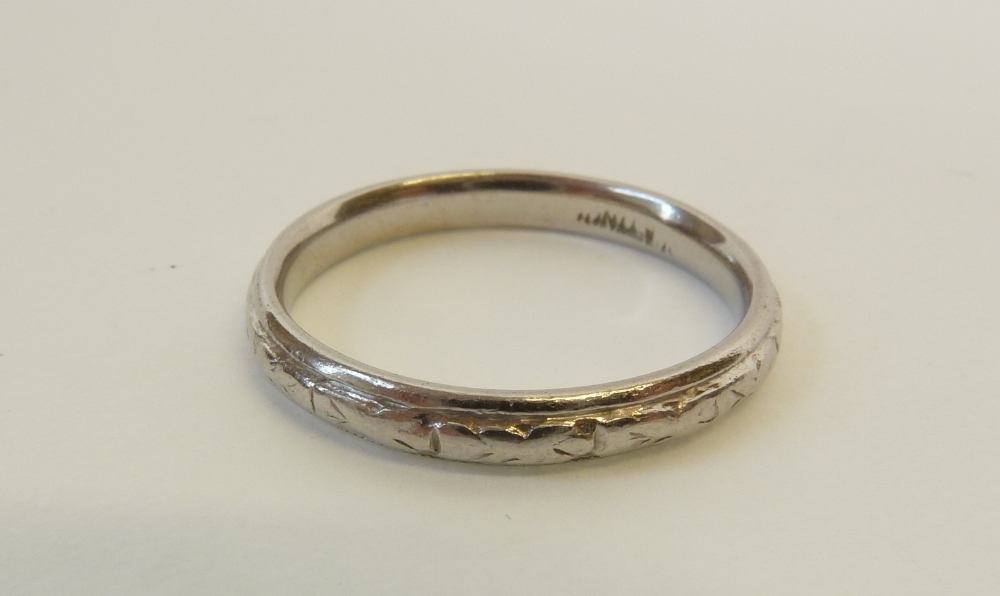 A STAMPED PLATINUM WEDDING RING, with bellhusk design, 4.2g