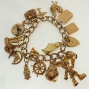 A 9CT GOLD CHARM BRACELET, WITH 17 GOLD CHARMS AND 9CT GOLD PADLOCK CLASP, Birmingham 1975, 35.8g