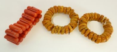 A PAIR OF IMITATION AMBER CHIP BRACELETS AND A DYED CORAL BRANCH BRACELET (3)