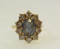 18ct GOLD CLUSTER RING, centrally claw set with a pale sapphire within a surround of 10 small