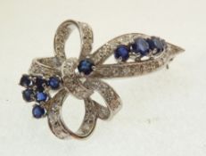 AN ATTRACTIVE 18ct WHITE GOLD BROOCH, of bowed ribbon form, set with 45 tiny diamonds and 11