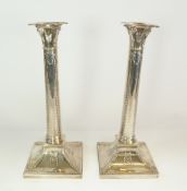 A PAIR OF WEIGHTED SILVER CANDLESTICKS, BY THOMAS BRADBURY & SONS, with bellhusk decoration and