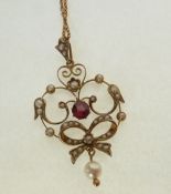 A STAMPED 9CT GOLD GARNET AND SEED PEARL OPEN WORK PENDANT, with central circular garnet and seed