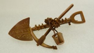 A STAMPED 9CT GOLD SOUTH AFRICAN GOLD MINING BROOCH, formed of crossed spade, pickaxe, bucket and