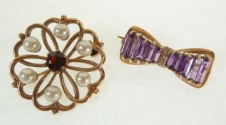 A 9CT GOLD PEARL AND GARNET SET FLOWER PATTERN BROOCH AND A 9CT GOLD AMETHYST AND DIAMOND BOW