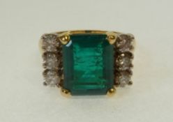 LADY`S 18CT GOLD, EMERALD AND SIX STONE DIAMOND RING, the four claw set cushion cut emerald, flanked