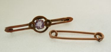 A STAMPED 9CT GOLD BAR BROOCH, CENTRE CLAW SET WITH AN AMETHYST AND FLANKED BY SEED PEARLS, AND A