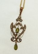 AN EDWARDIAN STAMPED 18CT GOLD, PERIDOT AND SEED PEARL OPENWORK PENDANT, 1 ¾" (4.5cm) long, ON 9CT