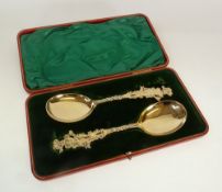 A PAIR OF VICTORIAN SILVER GILT SERVING SPOONS, with vine pattern handles and tops in the form of