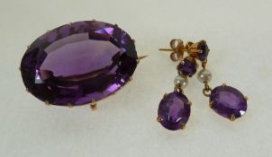 A GOLD FRAMED LARGE OVAL MIXED CUT AMETHYST BROOCH, AND A PAIR OF AMETHYST AND PEARL 9CT GOLD