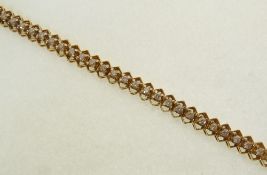 A STAMPED 14CT GOLD AND DIAMOND FANCY LINK TENNIS BRACELET, the fifty-five brilliant cut diamonds
