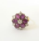 AN 18CT GOLD DIAMOND AND RUBY CLUSTER RING, centre set with a 0.18ct (approx.) diamond, with a petal