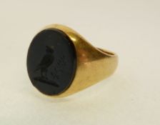 A GENT`S STAMPED 18CT GOLD HARDSTONE INTAGLIO RING, carved with an owl, 9.4g