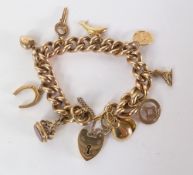9ct GOLD HEAVY CURB LINK CHARM BRACELET, with padlock clasps, 89.8gms all in