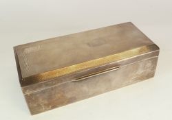 AN ENGINE TURNED SILVER CASED TABLE CIGARETTE BOX, with broadly canted long side, 7 1/8" x 3 ¾" x