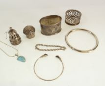 A REPOUSSE SILVER BOTTLE LID, A SILVER SUGAR CASTOR LID, TWO SILVER COLOURED METAL NAPKIN RINGS, A