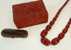 A NECKLACE OF BAKELITE BEADS, A CHEROOT HOLDER CASE AND A CINIBAR LACQUER LIDDED BOX