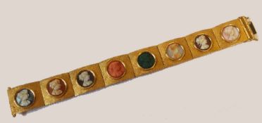 A STAMPED 18CT GOLD MULTI GEM AND HARDSTONE CAMEO BRACELET, formed of eight rectangular brushed gold
