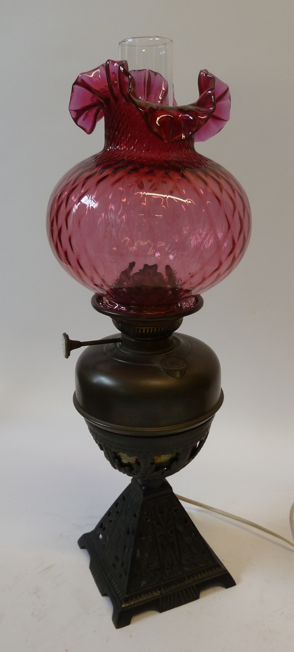 A VICTORIAN CAST IRON TABLE OIL LAMP, LAMPE NATIONAL, with pierced pyramidal base and reservoir