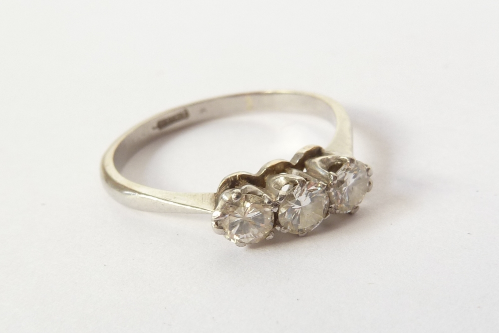 A PLATINUM RING SET WITH THREE SMALL BRILLIANT CUT DIAMONDS