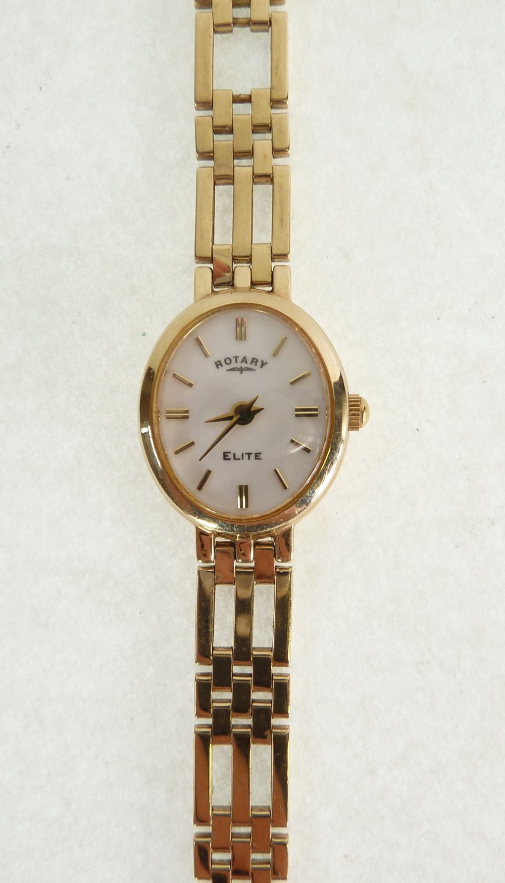 LADY`S ROTARY `ELITE` 9CT GOLD WRIST WATCH, the white oval dial with batons, WITH 9CT GOLD
