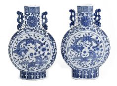 A pair of Chinese late 19th/20th century blue and white moonflasks, each of flattened globular form