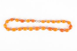 A Chinese amber coloured bead necklace of 25 graduated beads, possibly reconstituted, 29.1 grams