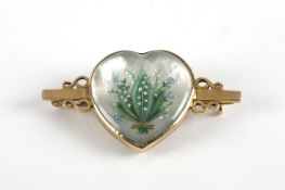 A rock crystal reverse carved and painted intaglio brooch, depicting lily of the valley on mother