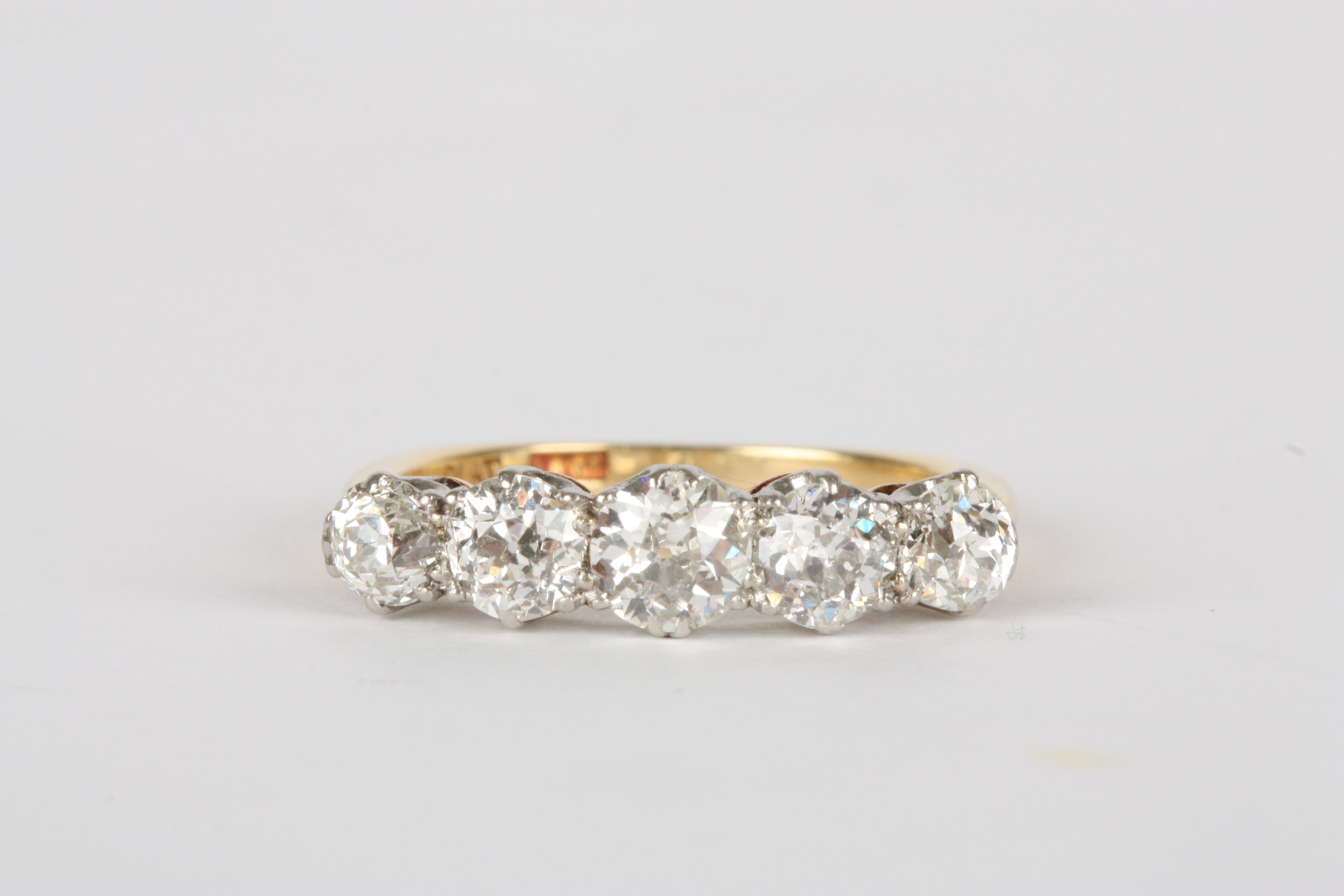 A five stone diamond ring set in 18ct yellow gold and platinum, the central stone of approximately