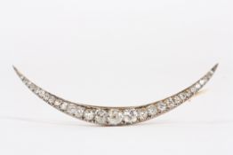 An Edwardian gold and diamond graduated crescent brooch, the central diamond approximately 0.45cts,