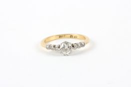 An 18ct gold diamond ring, set with approximately ¼ carat diamond and six diamonds to shoulders  In