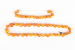 A Chinese amber coloured bead necklace of 33 graduated beads, together with a loose amber coloured