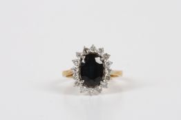 An 18ct gold diamond and sapphire cluster ring, of oval shaped form, with large central faceted