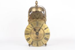 A late 19th century brass lantern clock, the bell strap surmounted by an acorn shaped finial, with