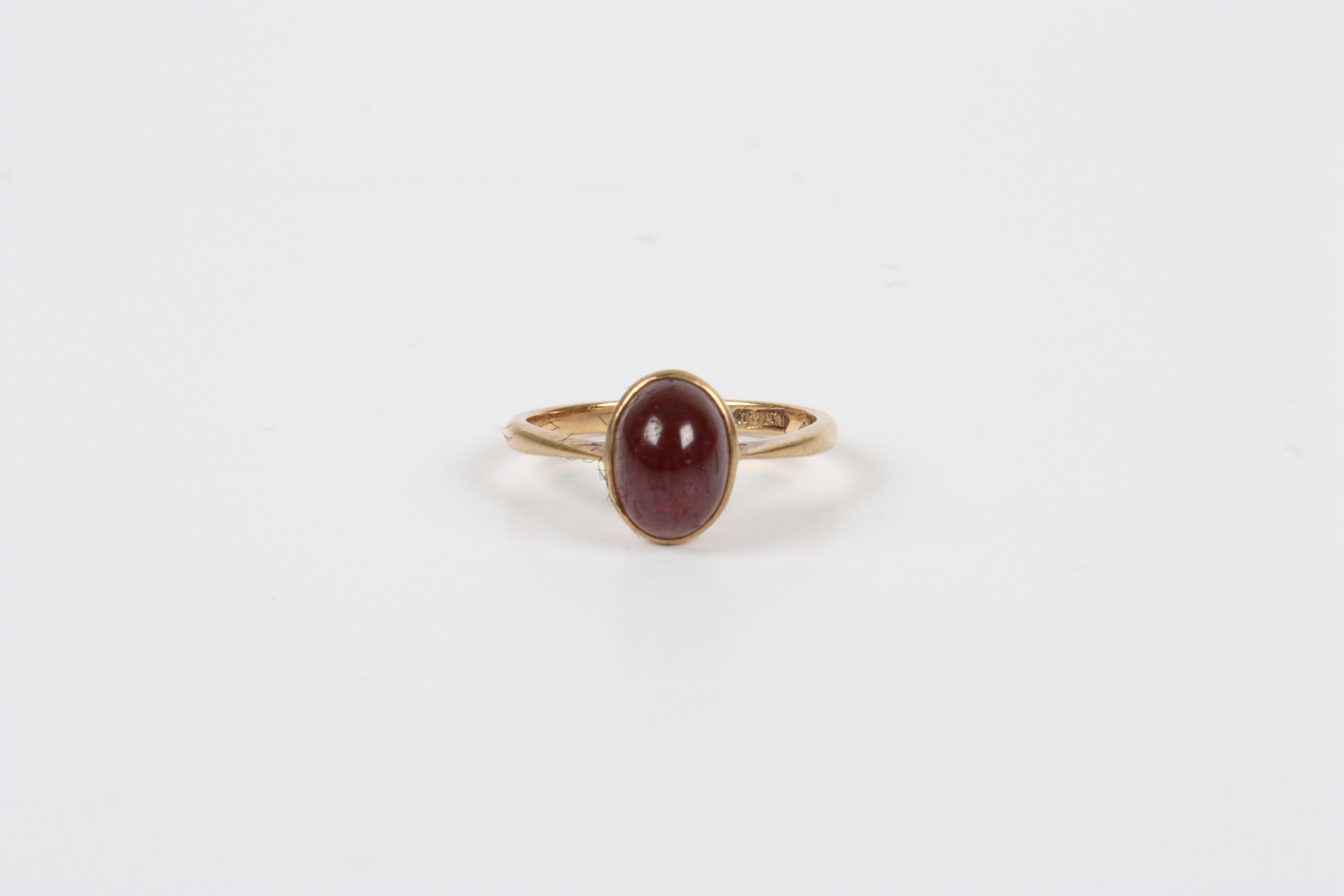 A 9ct gold and cabochon garnet ring, with rub over setting, size K½  Good condition.